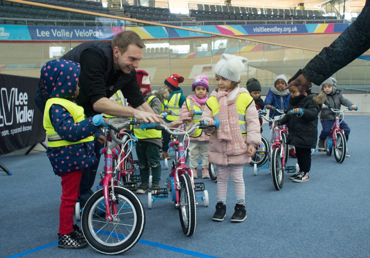 Man passing a bike to a child