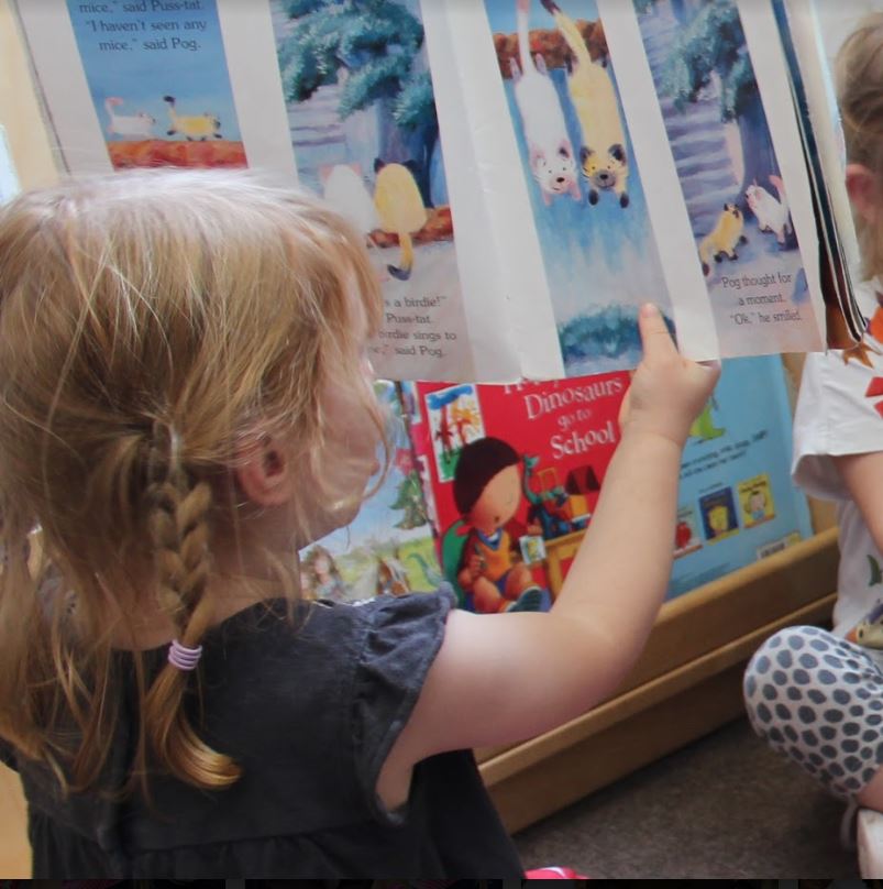 Little girl holding a reading book