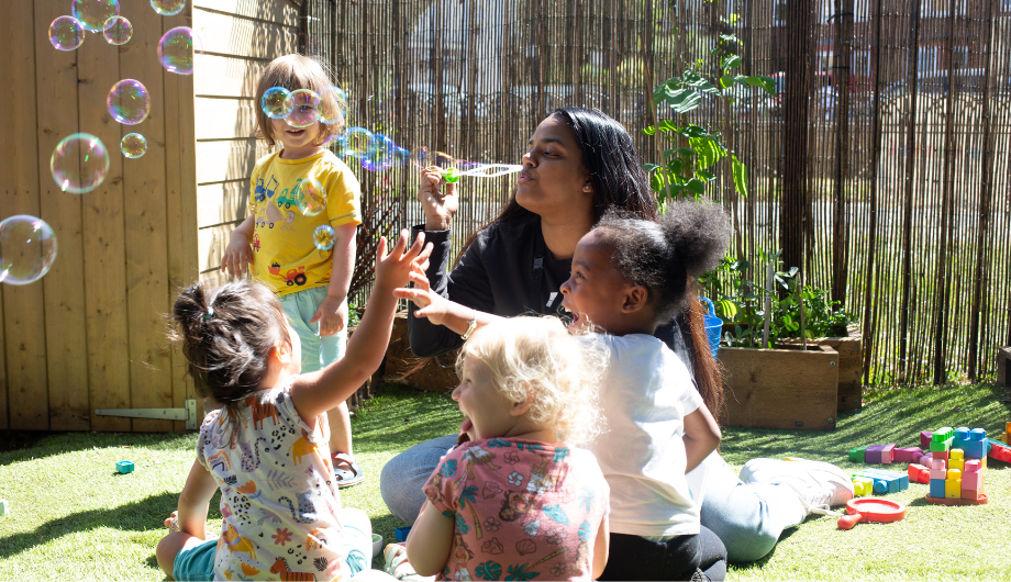 Staff blowing bubbles outside in the garden