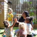 Staff blowing bubbles outside in the garden