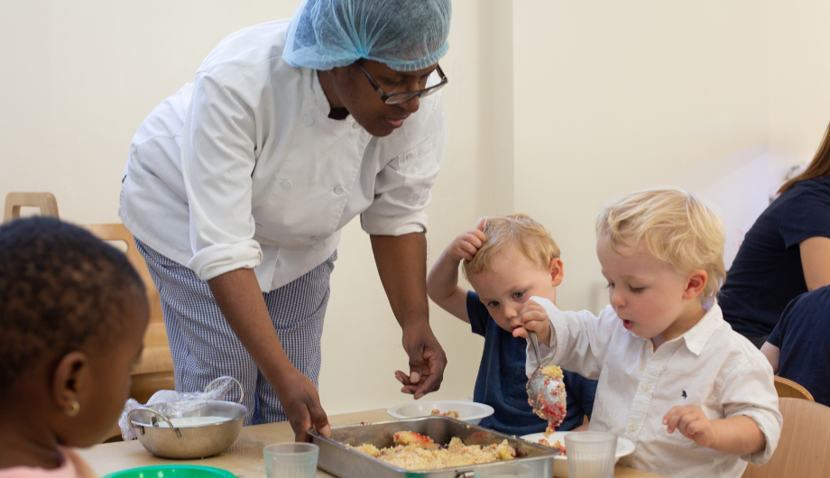 Chef serves children food in a nursery