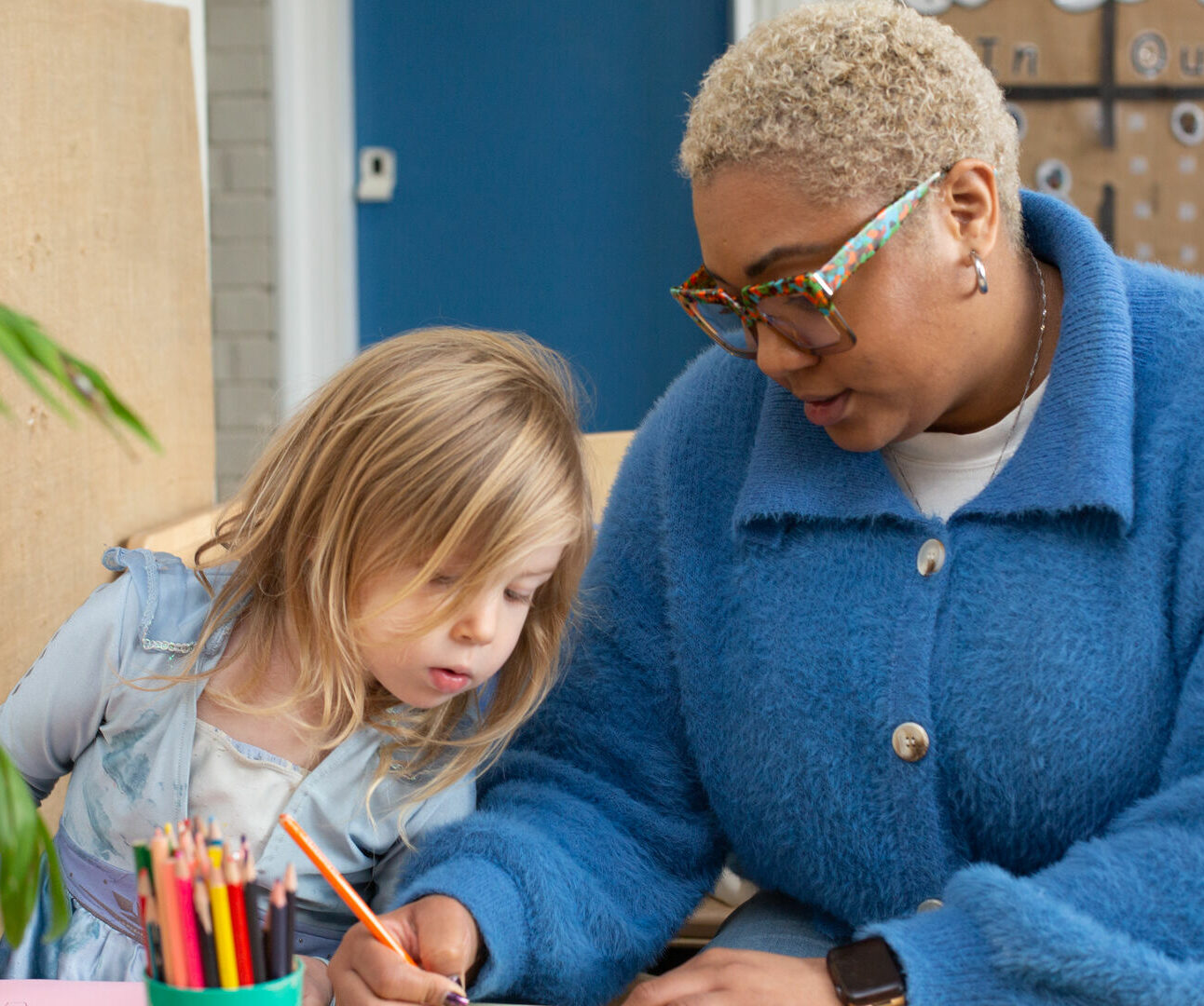 Child watching a teacher drawing with a pencil