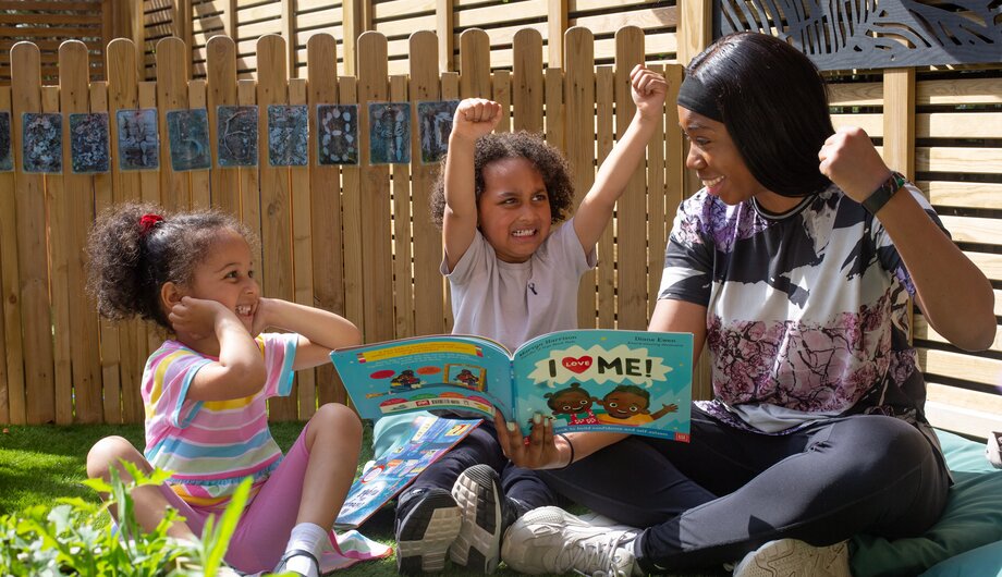 A teacher reading book to two preschoolers