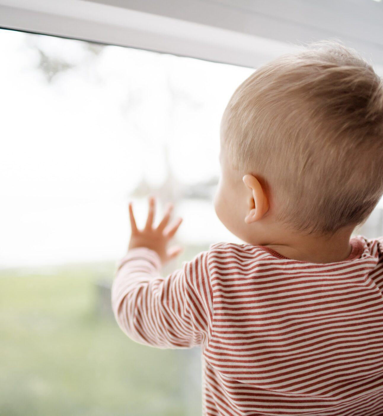 Image of a baby looking out of a window