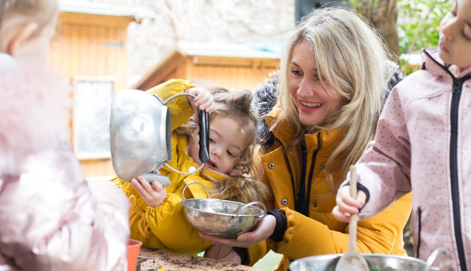 Outdoor play, child pouring water into a bowl for gardening.