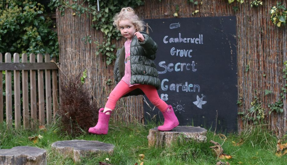 Child walking over stepping stones made from logs