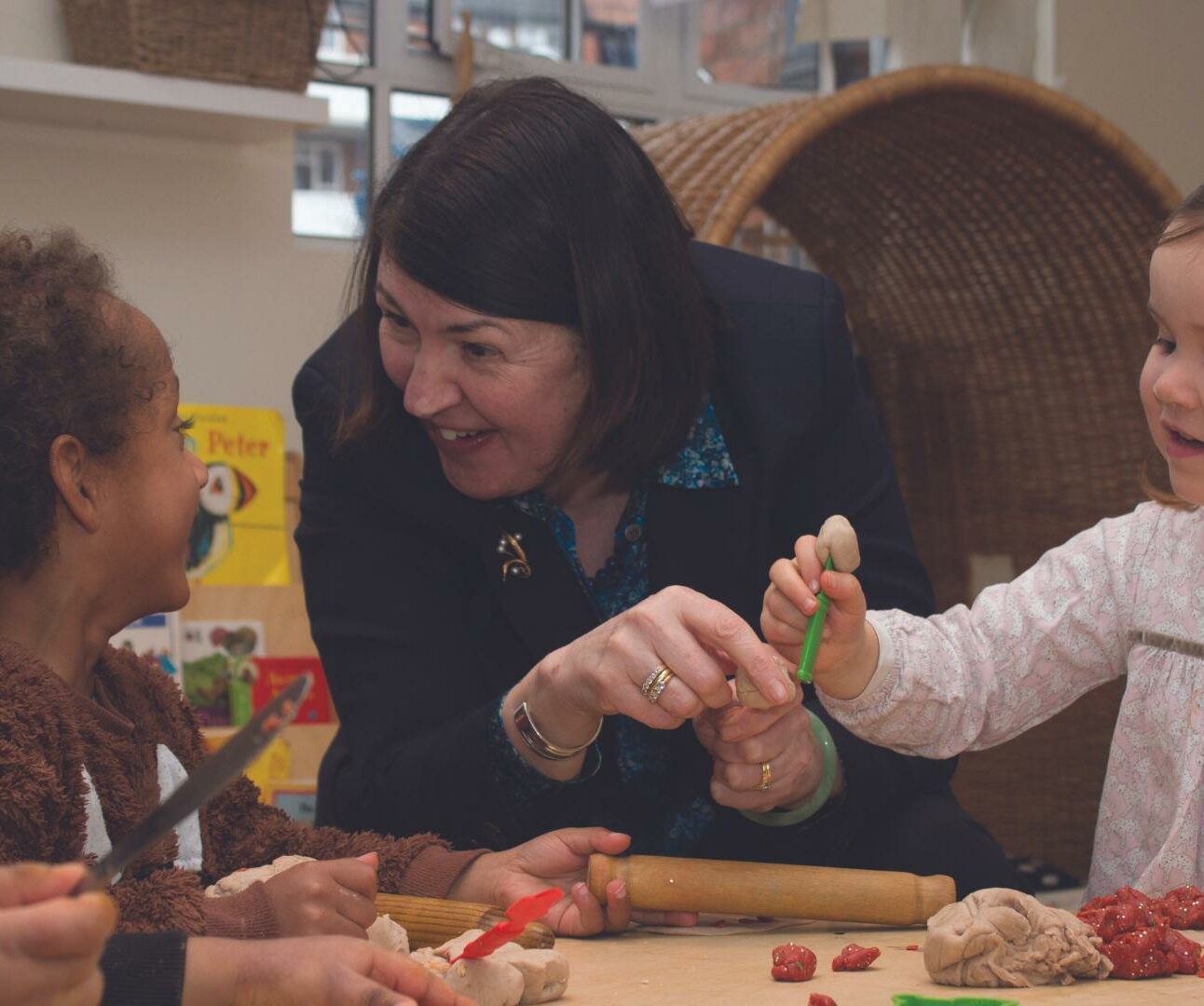 June at a nursery engaging in an activity with children