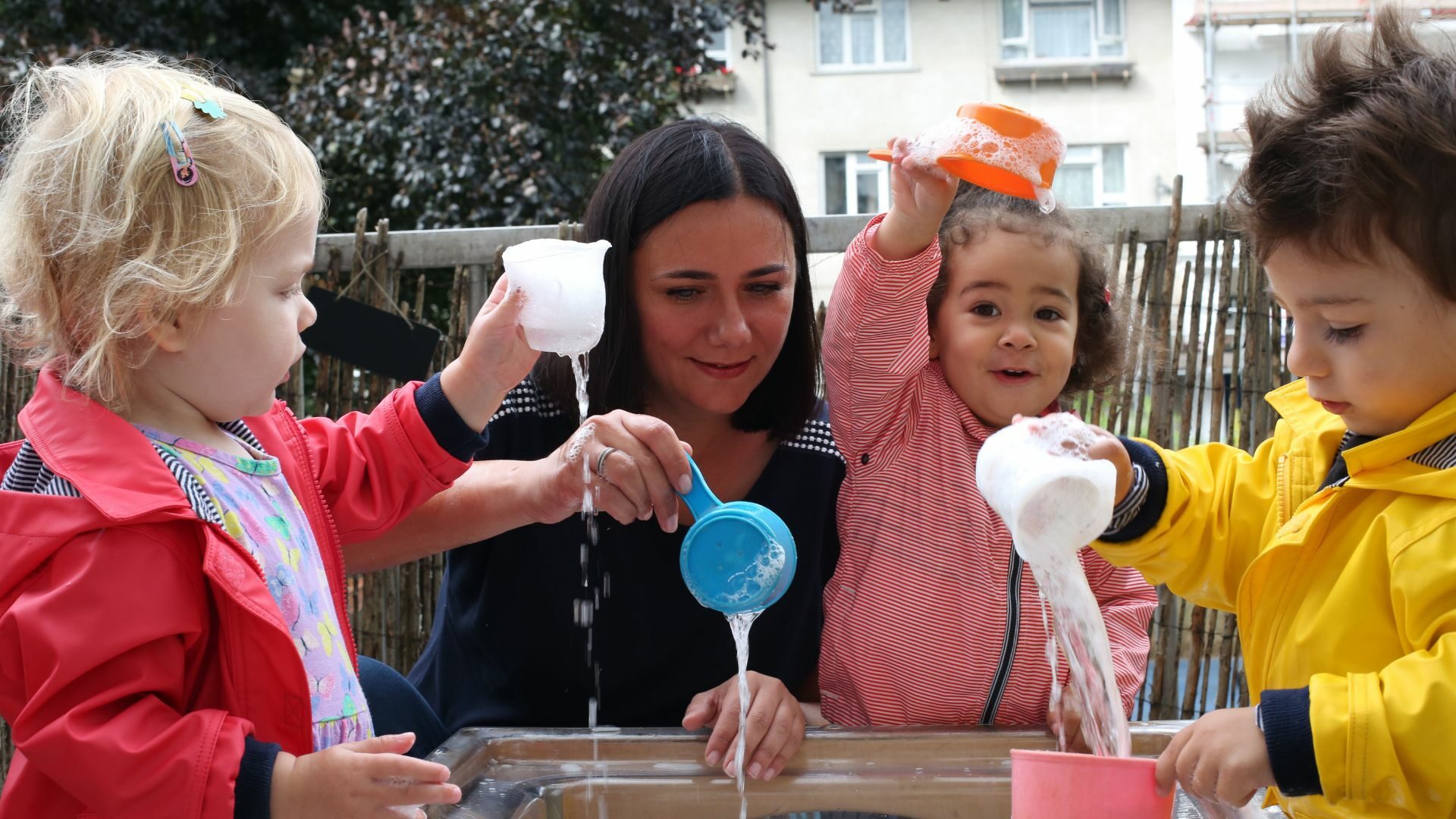 Staff and children playing with water and cups