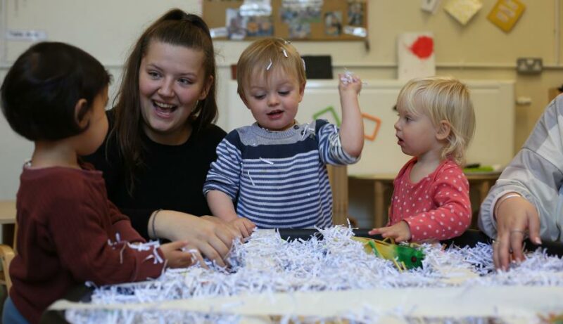 Staff and children playing with shredded paper