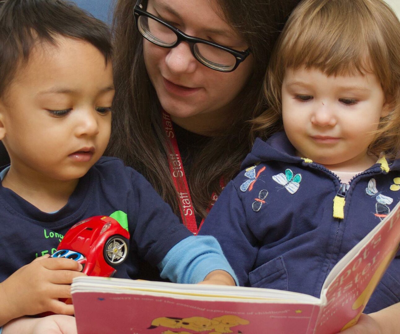 Nursery teacher reading with children