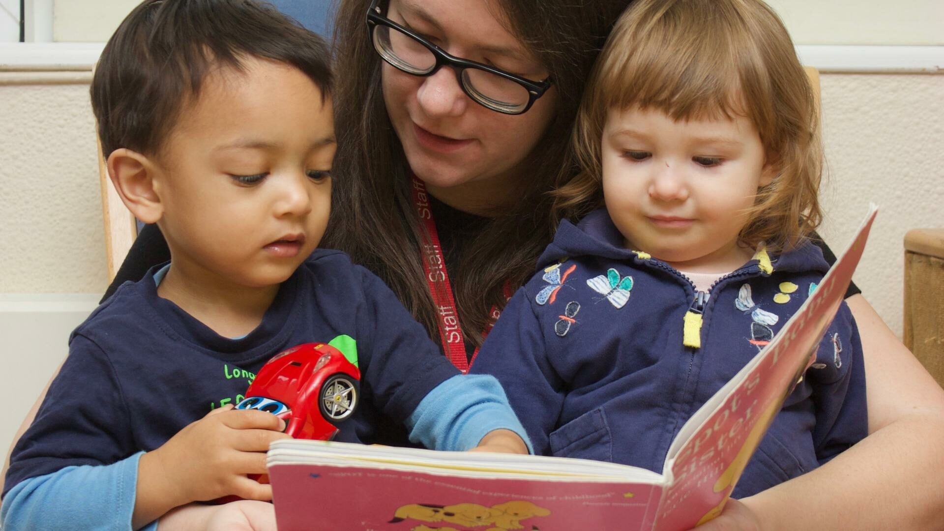 Nursery teacher reading with children