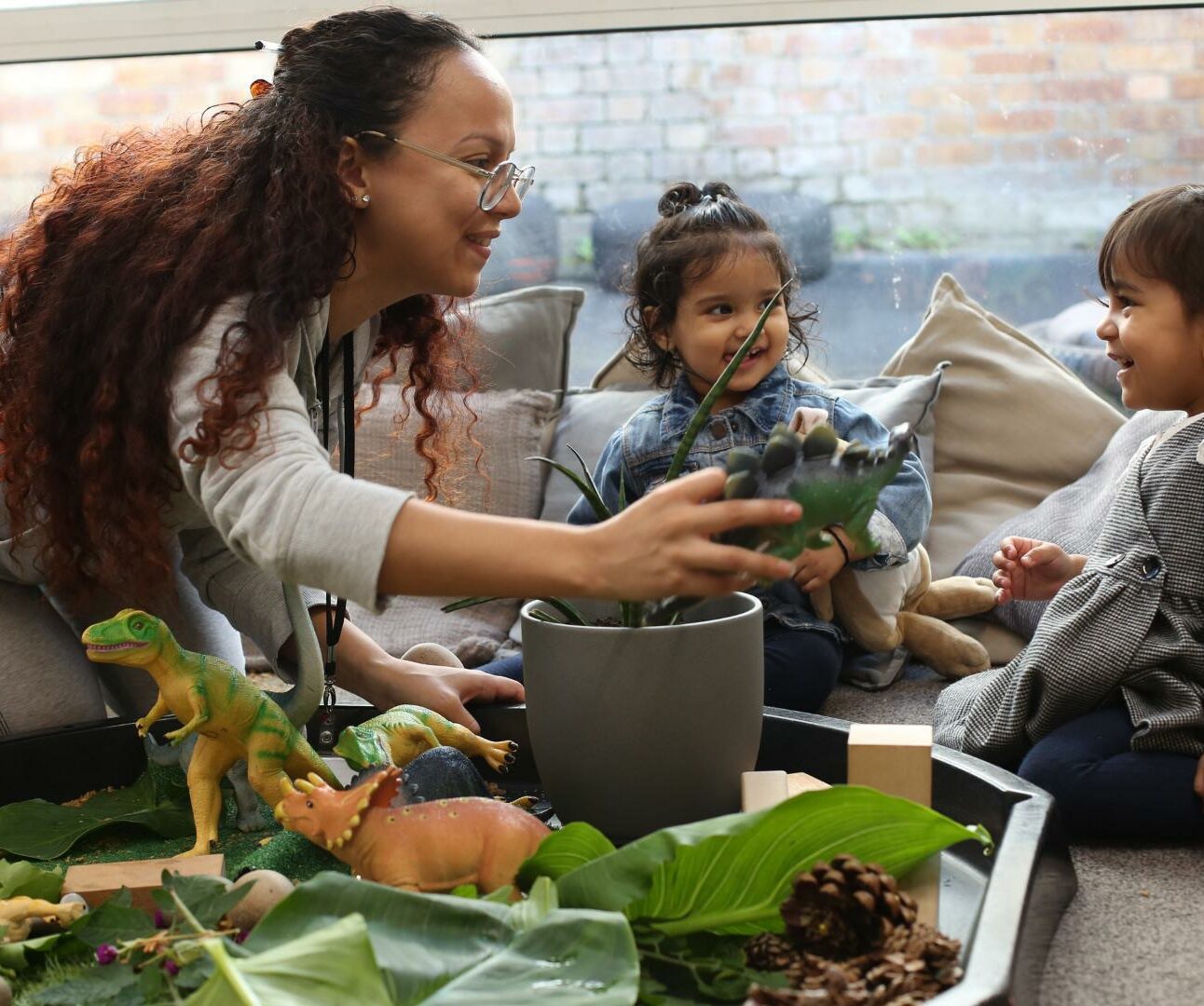 staff and children playing with dinosaurs