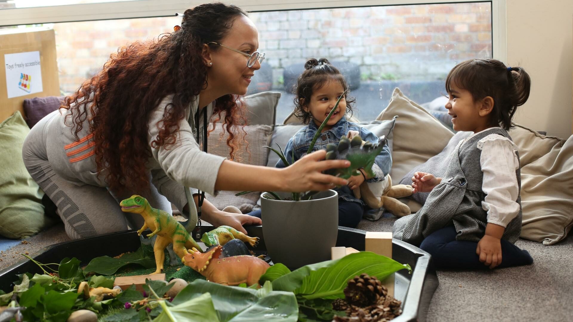 staff and children playing with dinosaurs