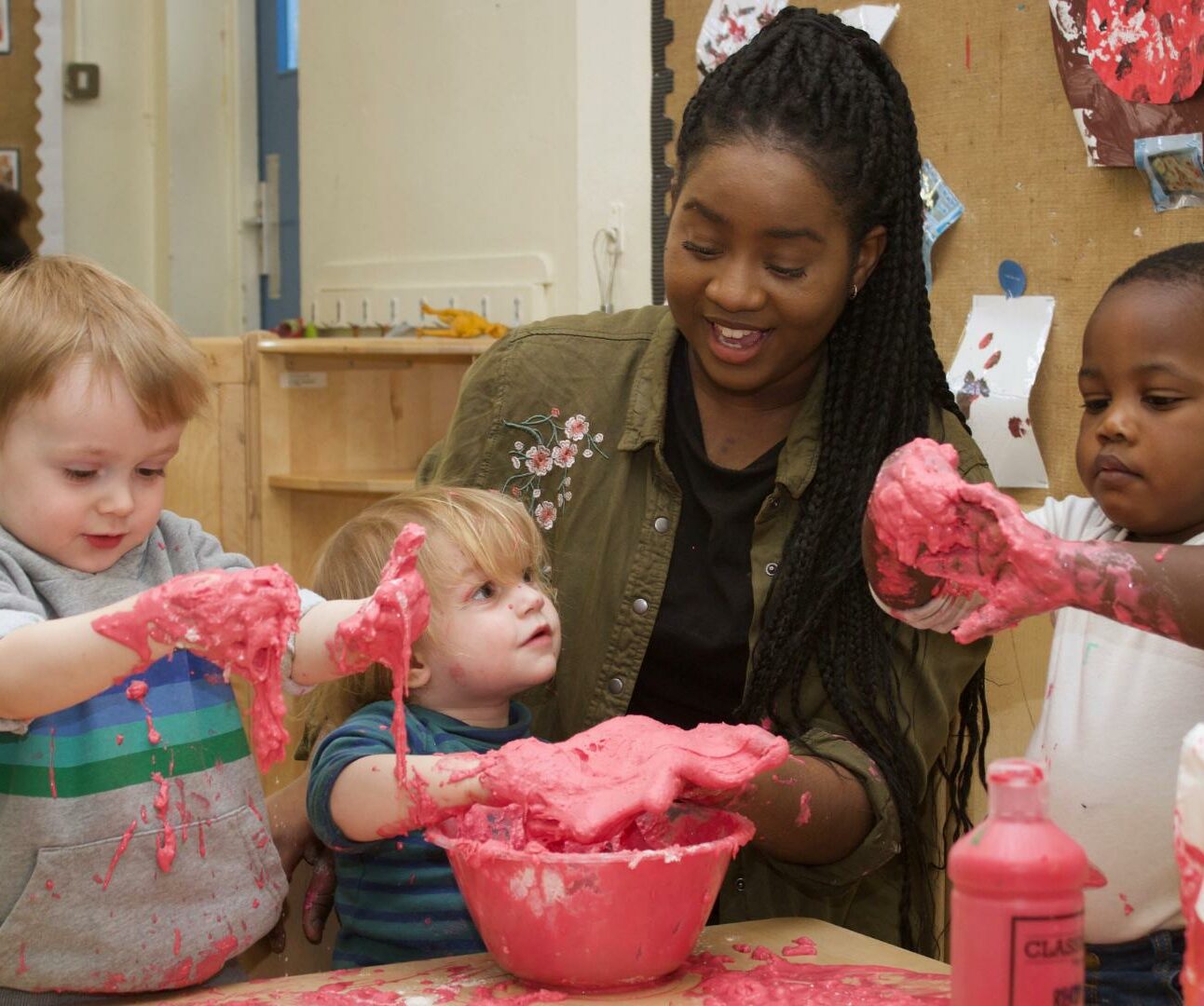 Children and staff getting stuck into messy play with some flour and paint