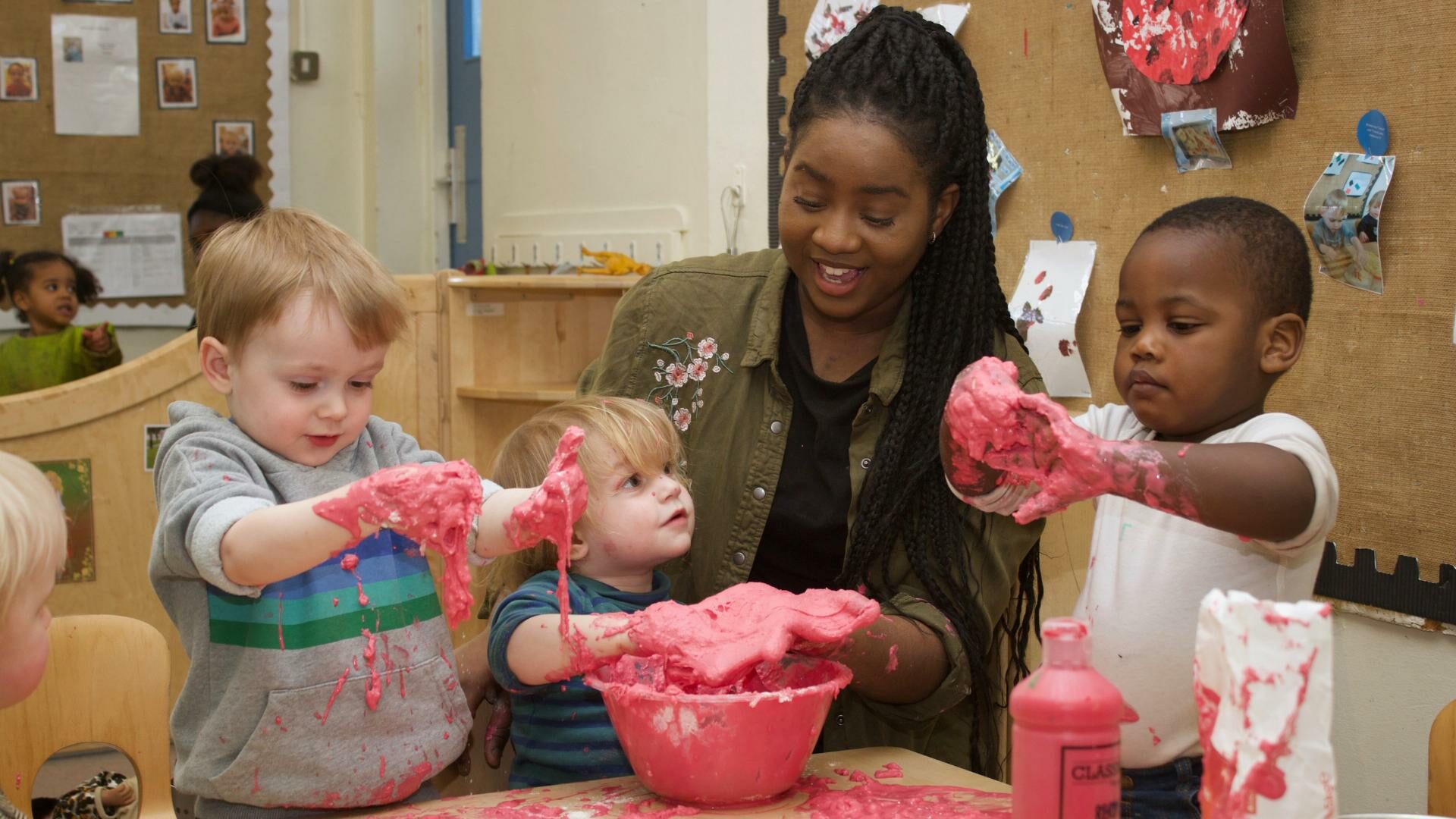 Children and staff getting stuck into messy play with some flour and paint