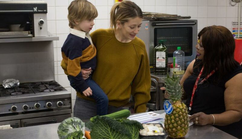 staff showing some LEYF recipes to a parent for them to try at home