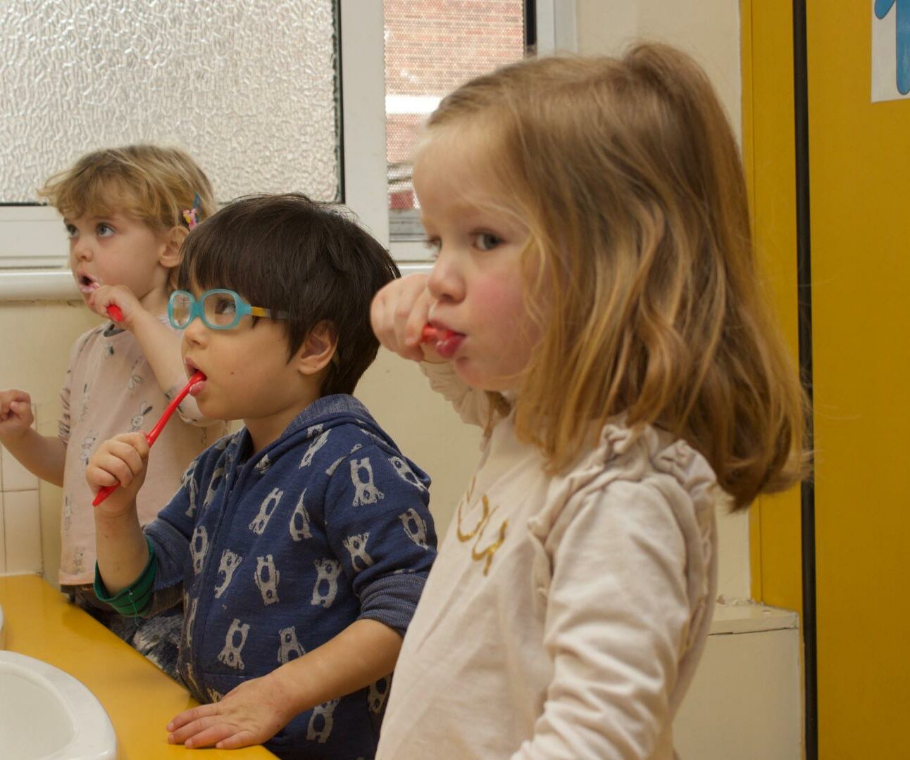 Children practicing how to brush their teeth after lunch