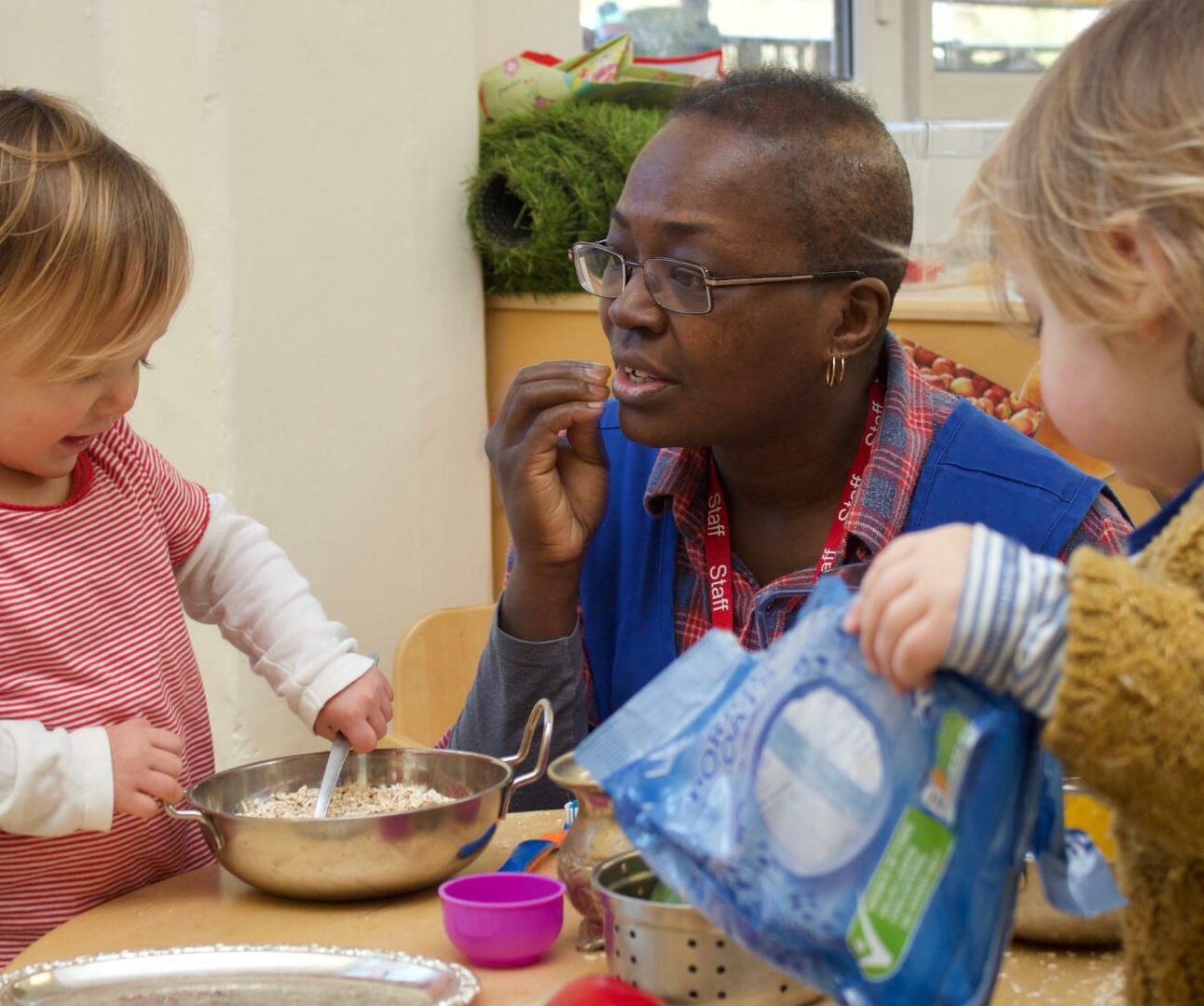 Staff using makaton/sign language with toddler in the home corner