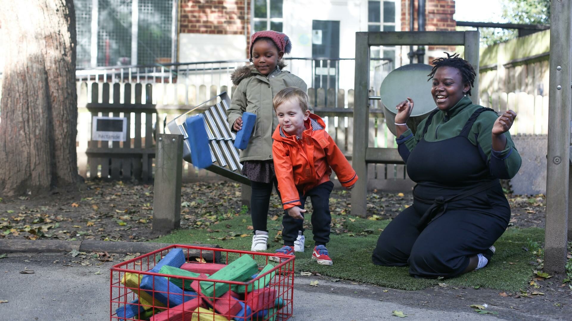 staff and children outside playing through foams into a box