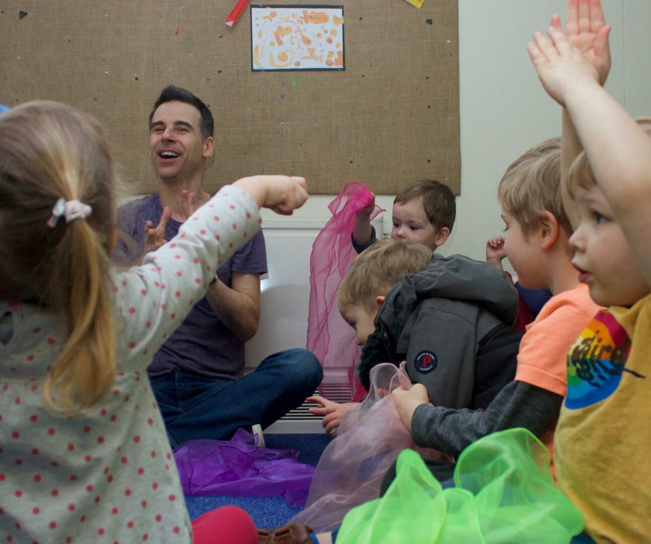 Staff and children sitting on the carpet using mesh/see through materials