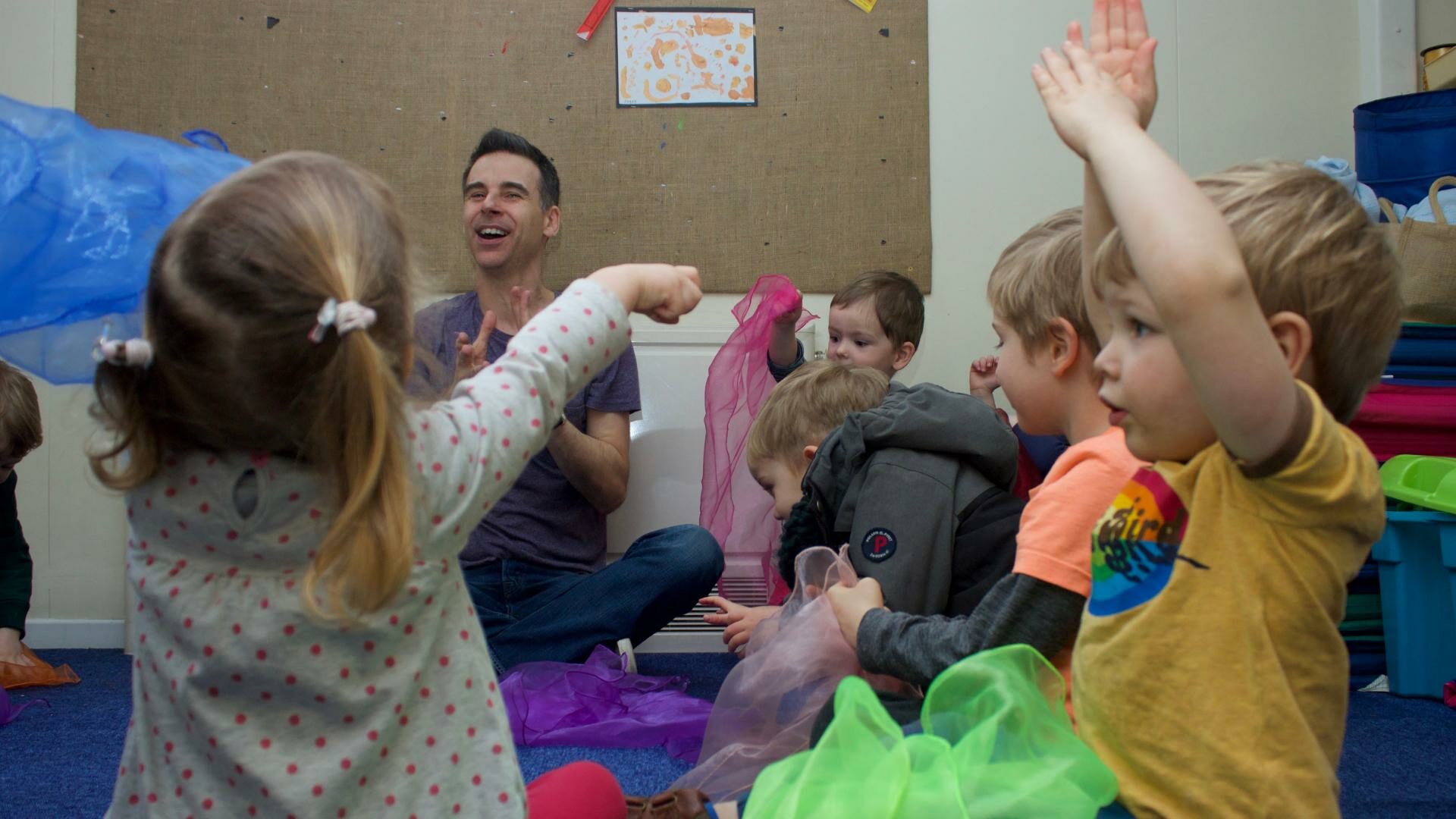 Staff and children sitting on the carpet using mesh/see through materials