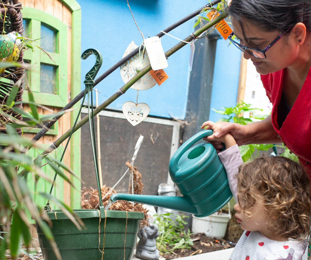 Children watering plants with the staff's help