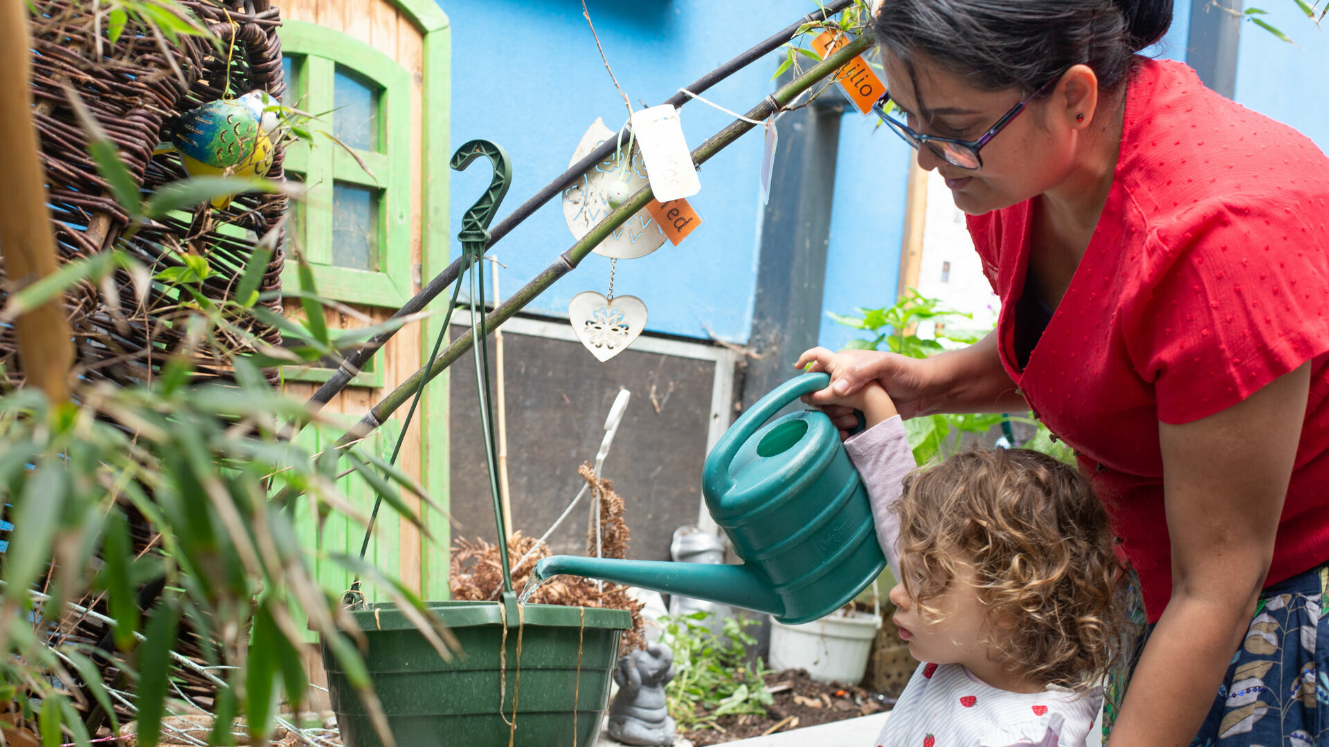 Children watering plants with the staff's help