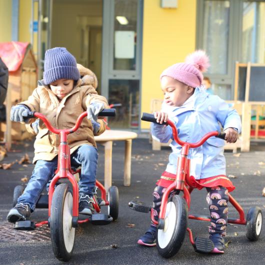 Children outside in the garden riding their bikes