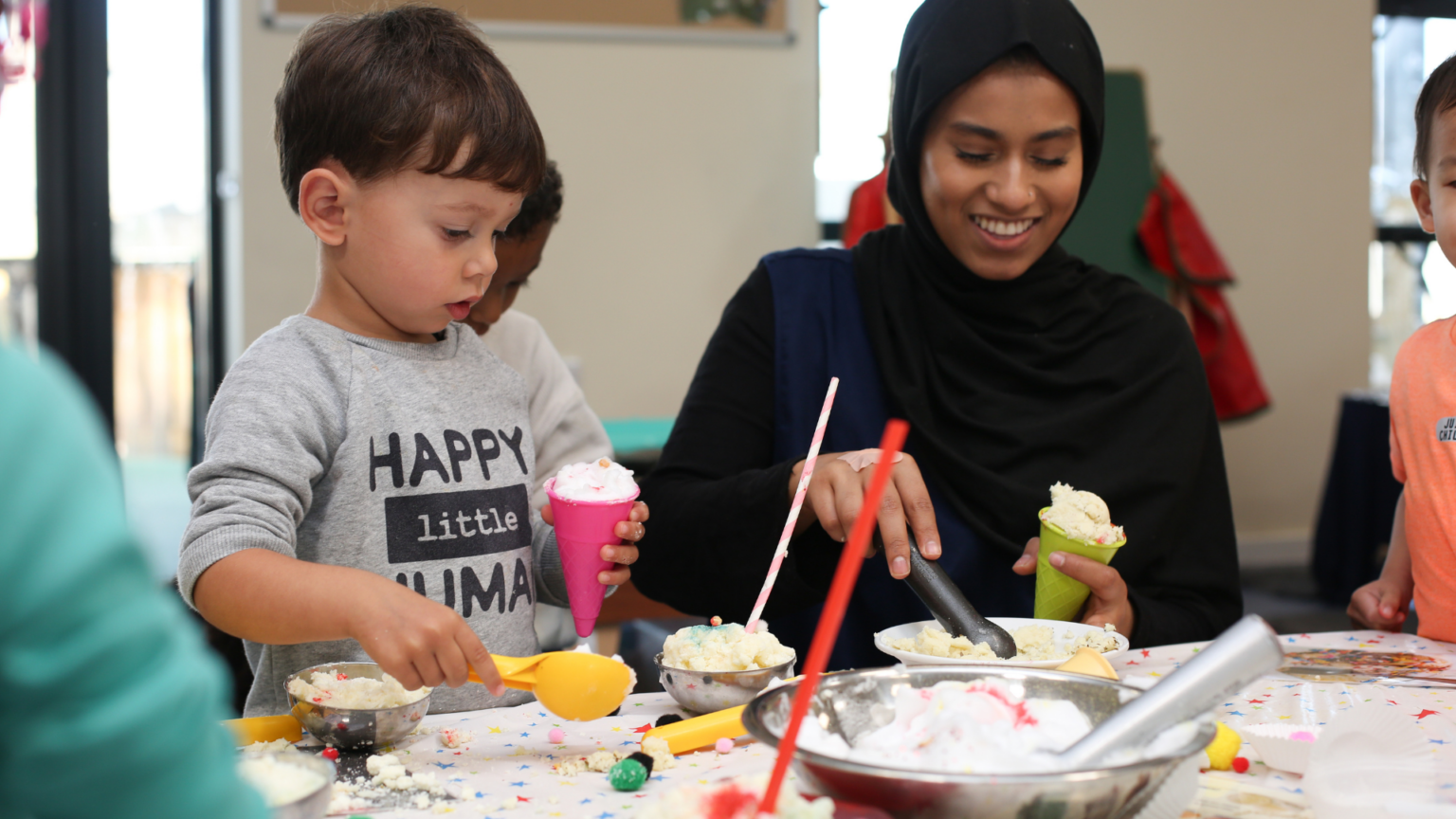 Staff making ice cream cones with child