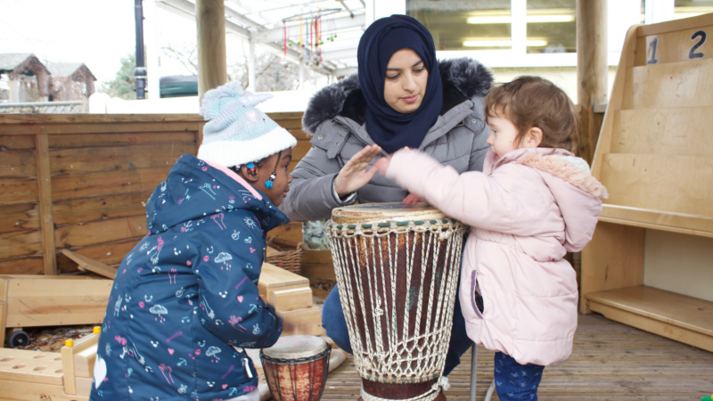 Staff and children drumming together