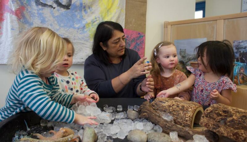 Staff member playing with children with ice