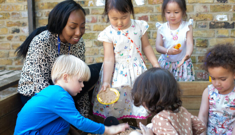 Staff and children building sandcastles