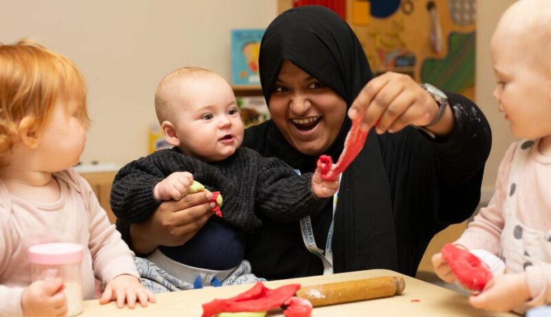 Teacher with three babies playing with playdough