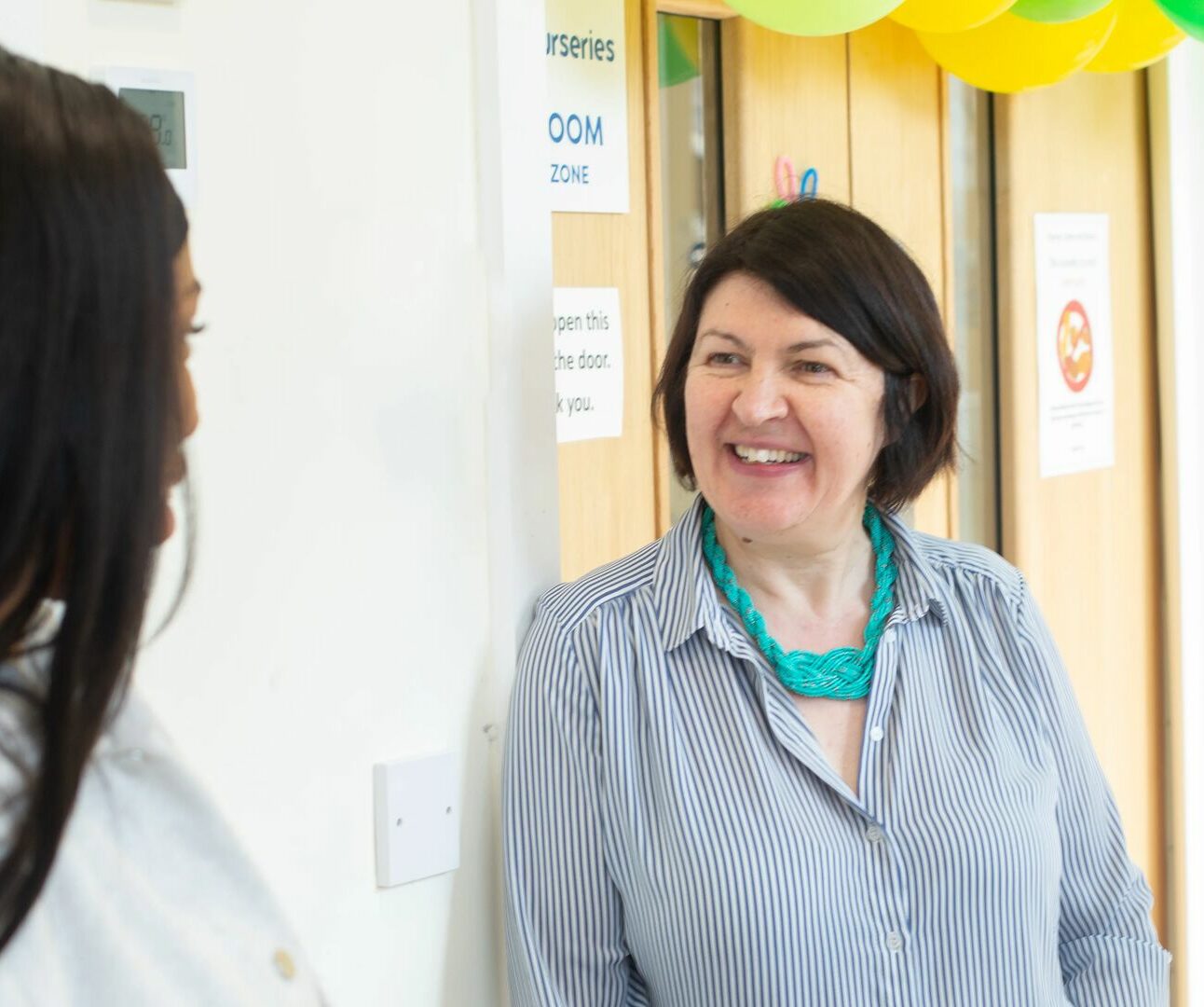 June visiting Thames Reach Nursery and having a conversation with a member of staff.
