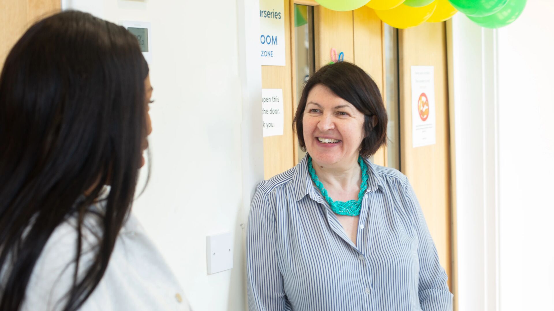 June visiting Thames Reach Nursery and having a conversation with a member of staff.