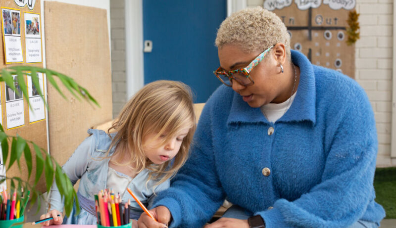 Child looking at a teacher drawing at Brixton Garden Nursery