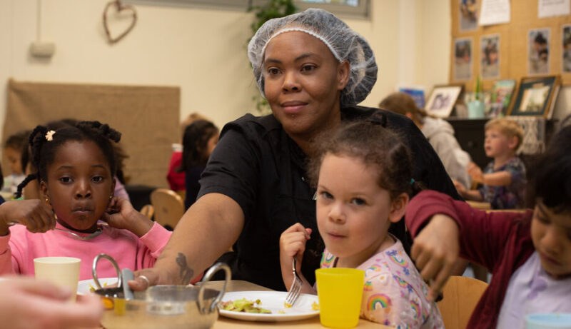 Marks Gate Chef at dinner table helping children to serve food