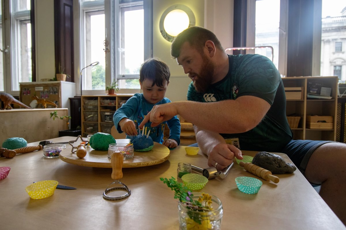 Pre-schoolers playing with playdough with male teacher